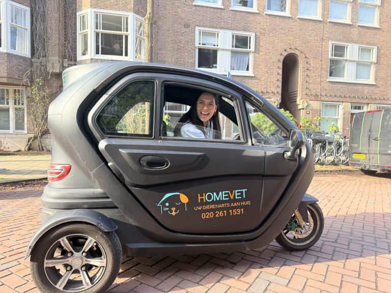 HomeVet veterinarian in a branded three-wheeled electric vehicle